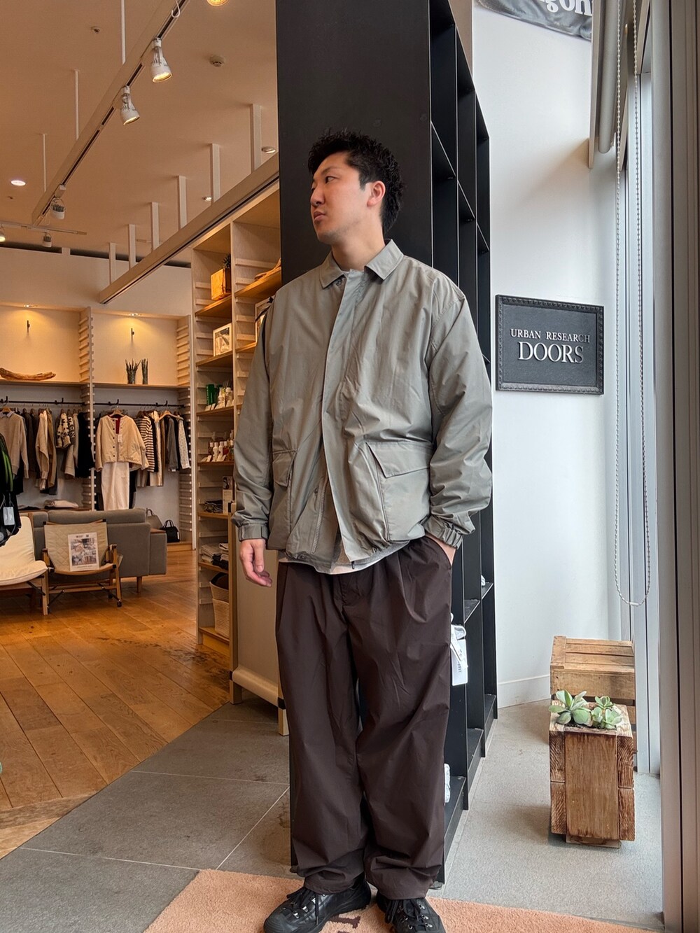 グリーン系のナイロンジャケットを着用したメンズの秋コーディネートの4枚目の写真