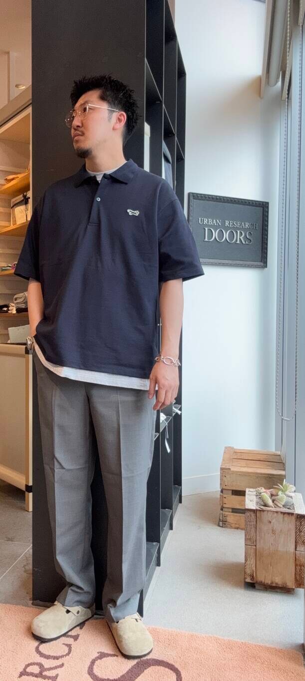ブルー系のポロシャツ、グレー系のスラックスを着用したメンズの夏コーディネートの3枚目の写真