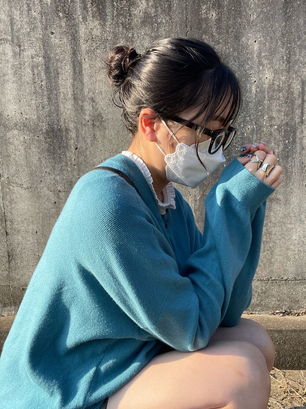 ブルー系のカーディガン/ボレロ、ブラック系のスカート、ブラック系のトートバッグを着用したレディースの秋コーディネートの2枚目の写真