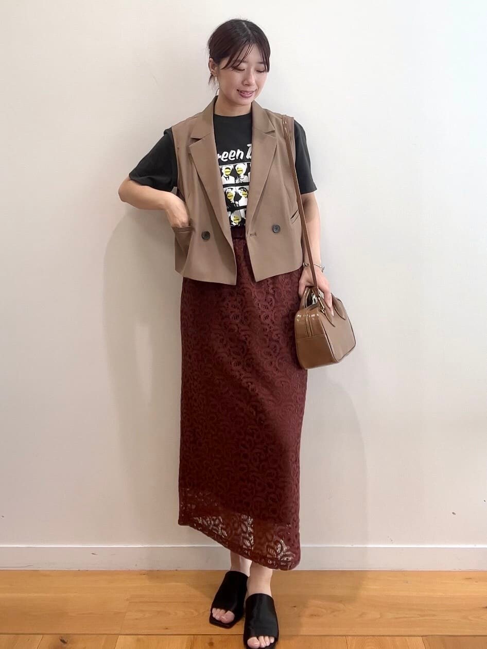 ブラウン系のベスト、グレー系のTシャツ/カットソー、ブラウン系のスカートを着用したレディースの秋コーディネートの2枚目の写真