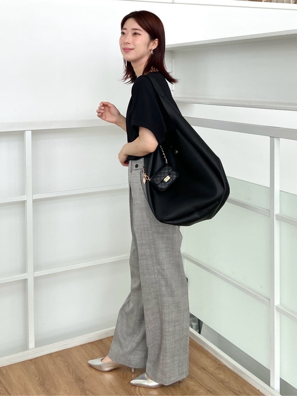 ブラック系のニット/セーター、グレー系のその他パンツ、ブラック系のトートバッグを着用したレディースの春コーディネートの2枚目の写真