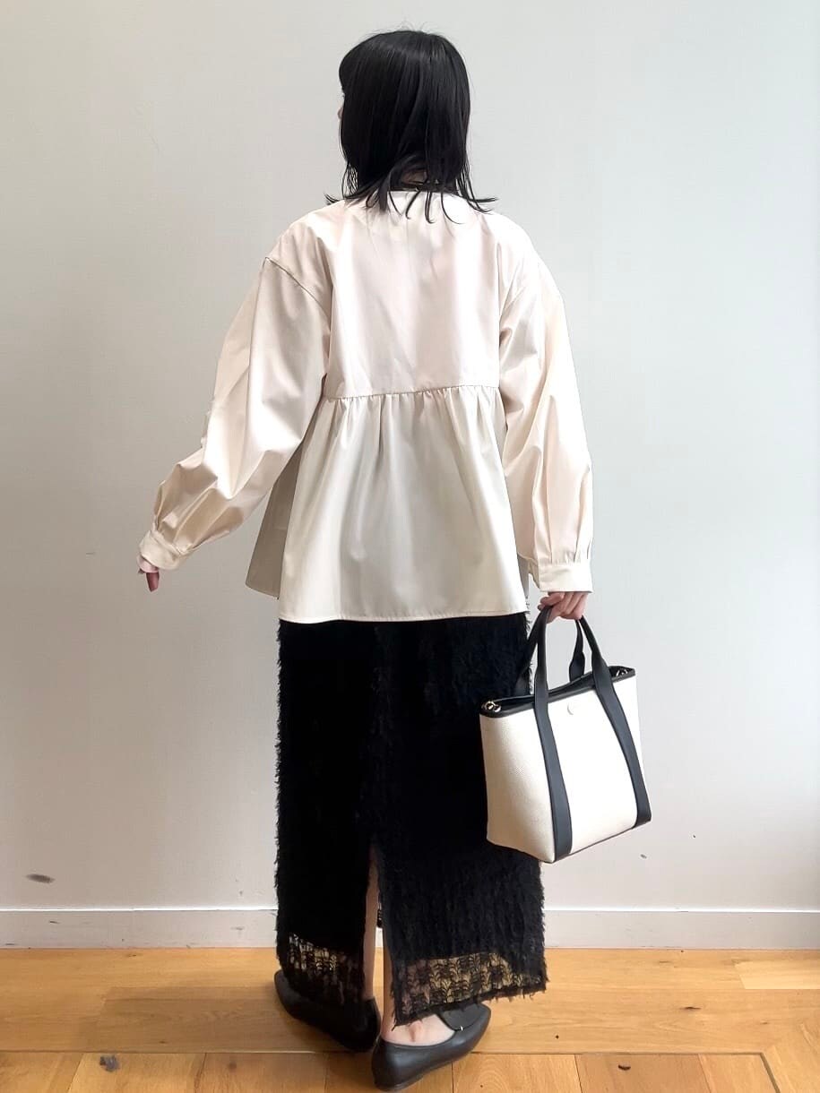 ピンク系のニット/セーター、ホワイト系のブルゾン、ブラック系のスカートを着用したレディースの春コーディネートの4枚目の写真