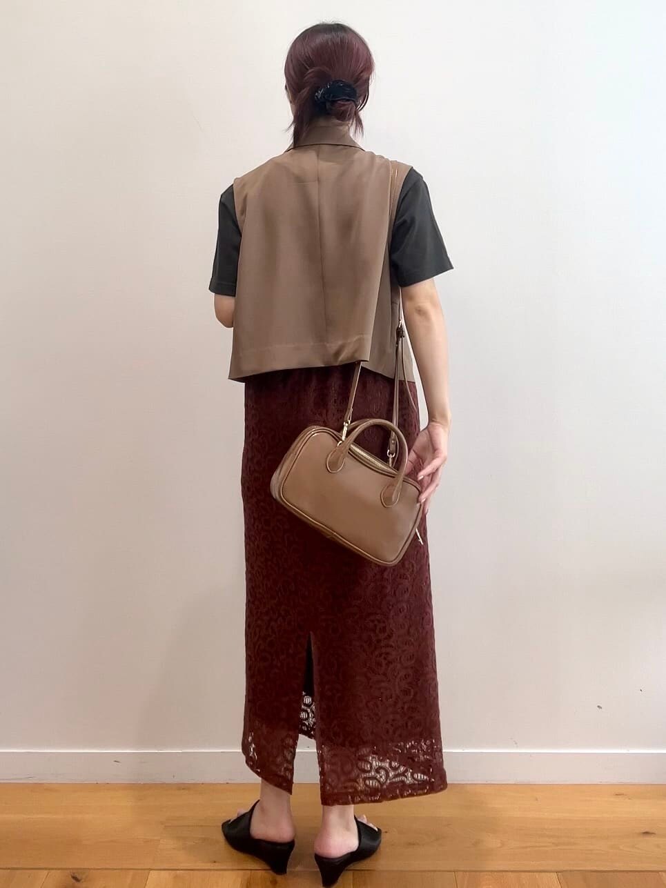 ブラウン系のベスト、グレー系のTシャツ/カットソー、ブラウン系のスカートを着用したレディースの秋コーディネートの4枚目の写真