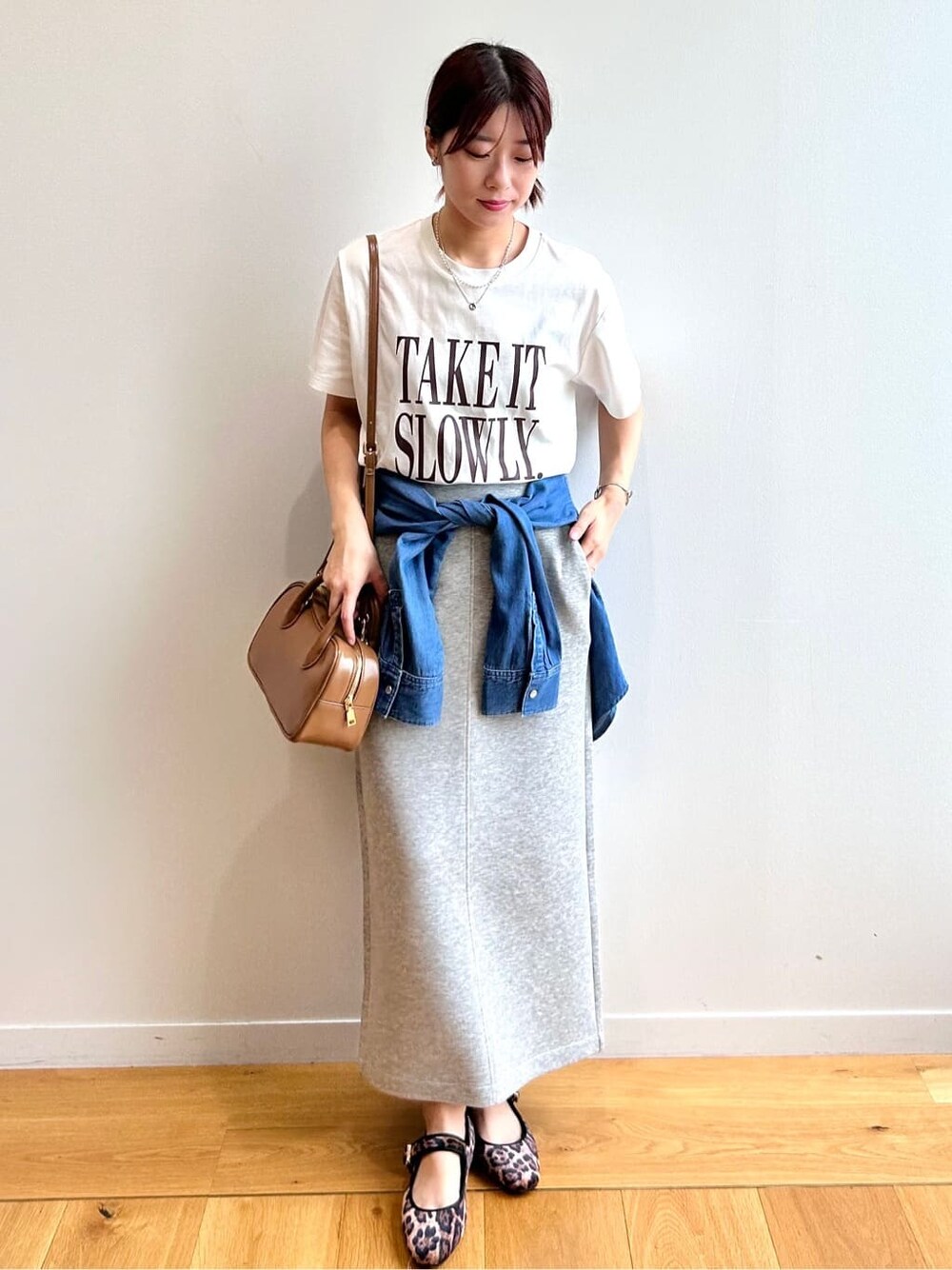 ホワイト系のTシャツ/カットソー、ブルー系のシャツ/ブラウス、グレー系のスカートを着用したレディースの秋コーディネートの2枚目の写真