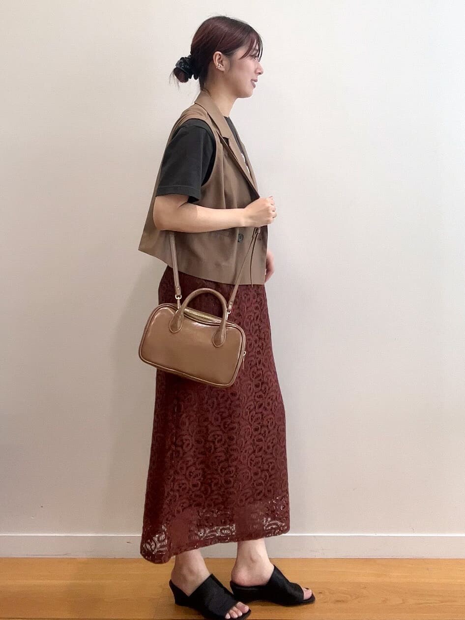 ブラウン系のベスト、グレー系のTシャツ/カットソー、ブラウン系のスカートを着用したレディースの秋コーディネートの3枚目の写真