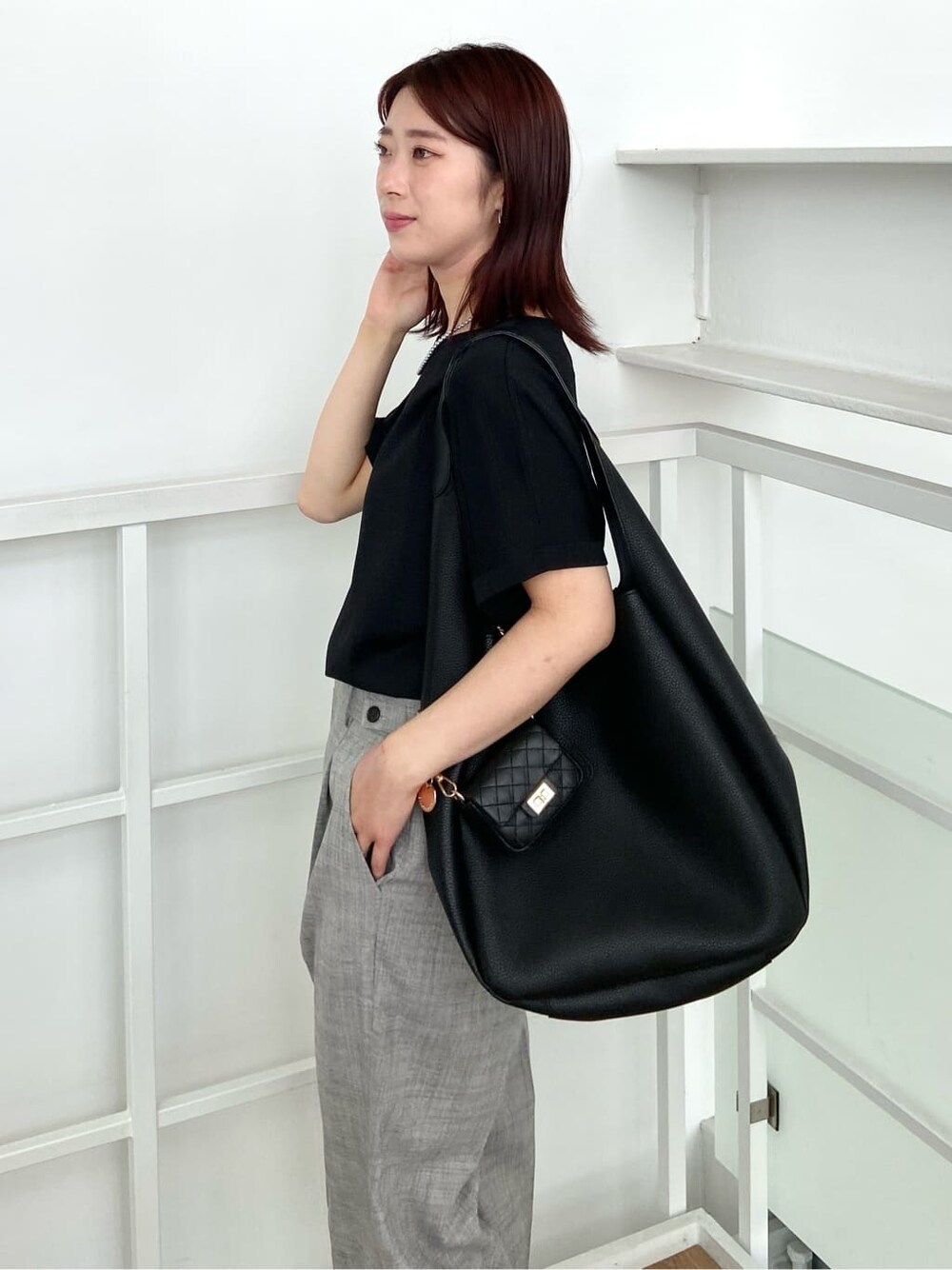 ブラック系のニット/セーター、グレー系のその他パンツ、ブラック系のトートバッグを着用したレディースの春コーディネートの6枚目の写真