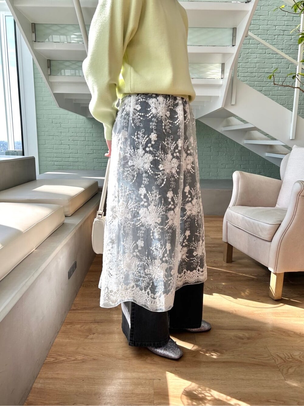 ブラック系のデニムパンツ、ホワイト系のショルダーバッグ、シルバー系のパンプスを着用したレディースの春コーディネートの6枚目の写真
