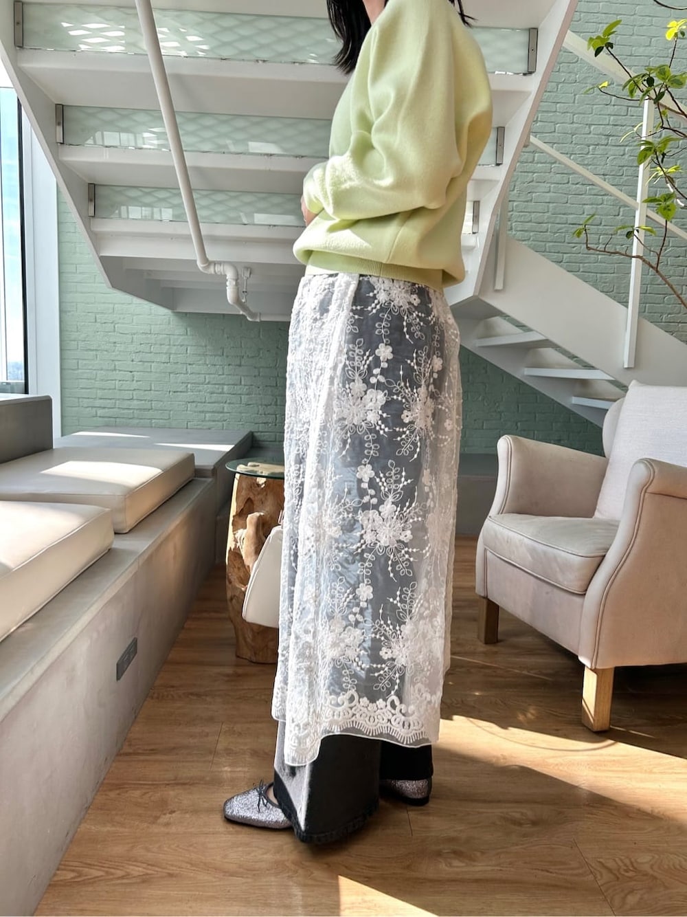 ブラック系のデニムパンツ、ホワイト系のショルダーバッグ、シルバー系のパンプスを着用したレディースの春コーディネートの7枚目の写真