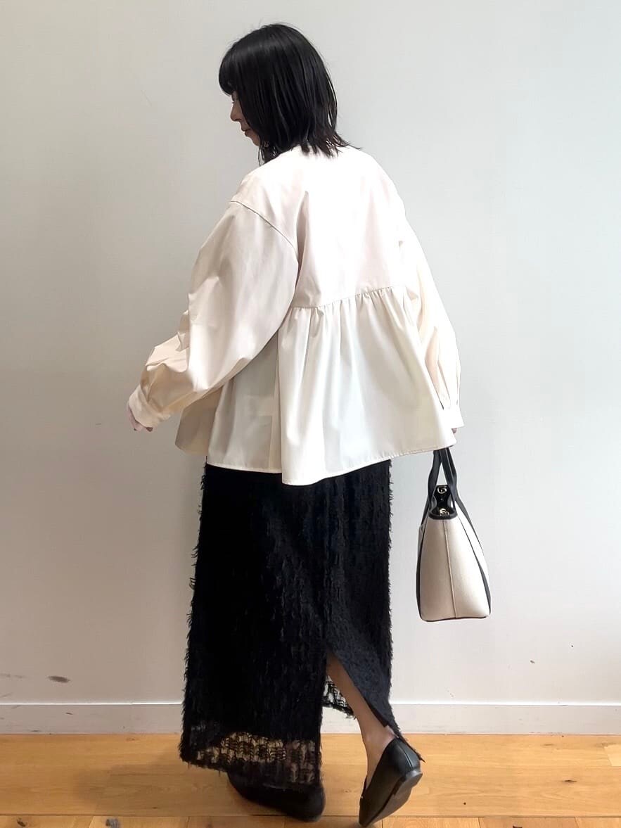 ピンク系のニット/セーター、ホワイト系のブルゾン、ブラック系のスカートを着用したレディースの春コーディネートの5枚目の写真