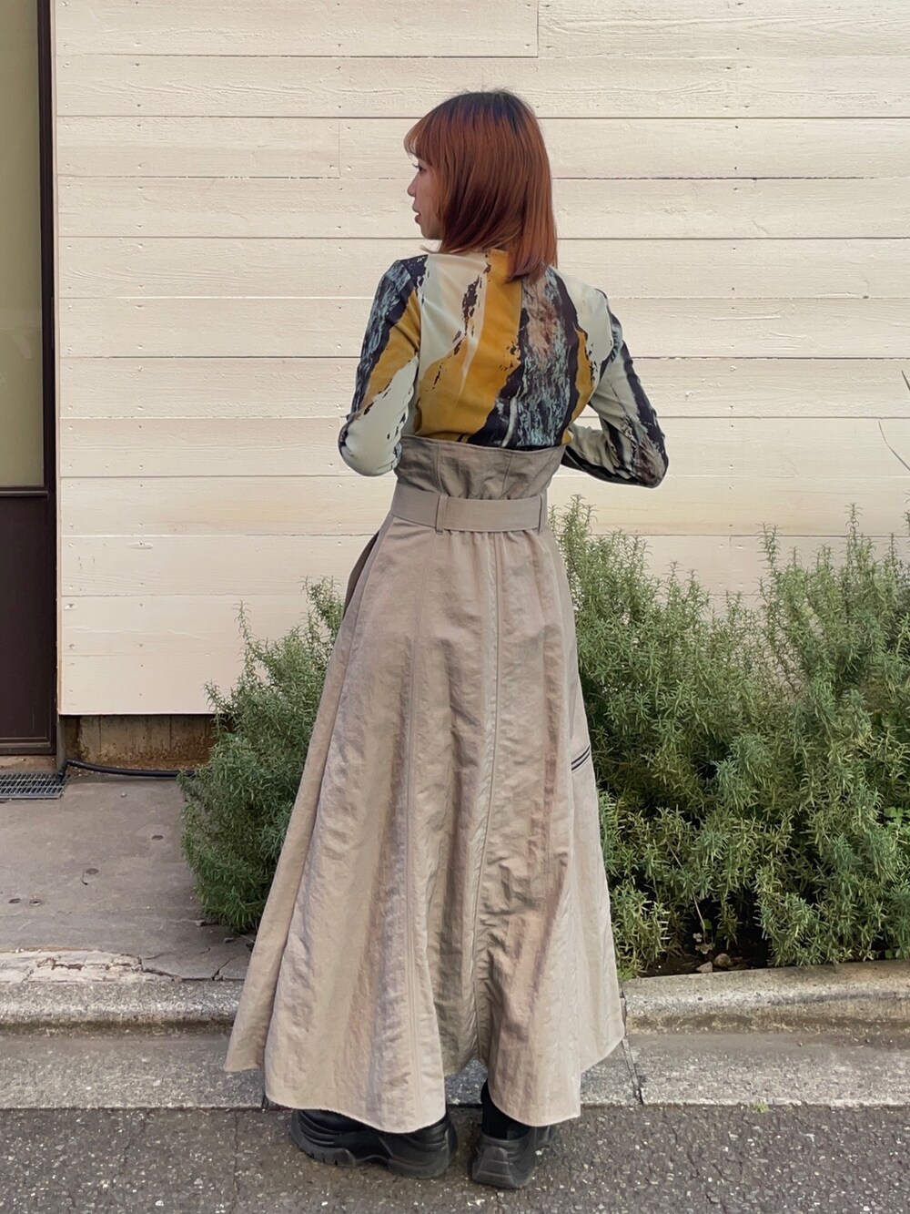 グレー系のスカート、ブラウン系のTシャツ/カットソーを着用したレディースの冬コーディネートの2枚目の写真