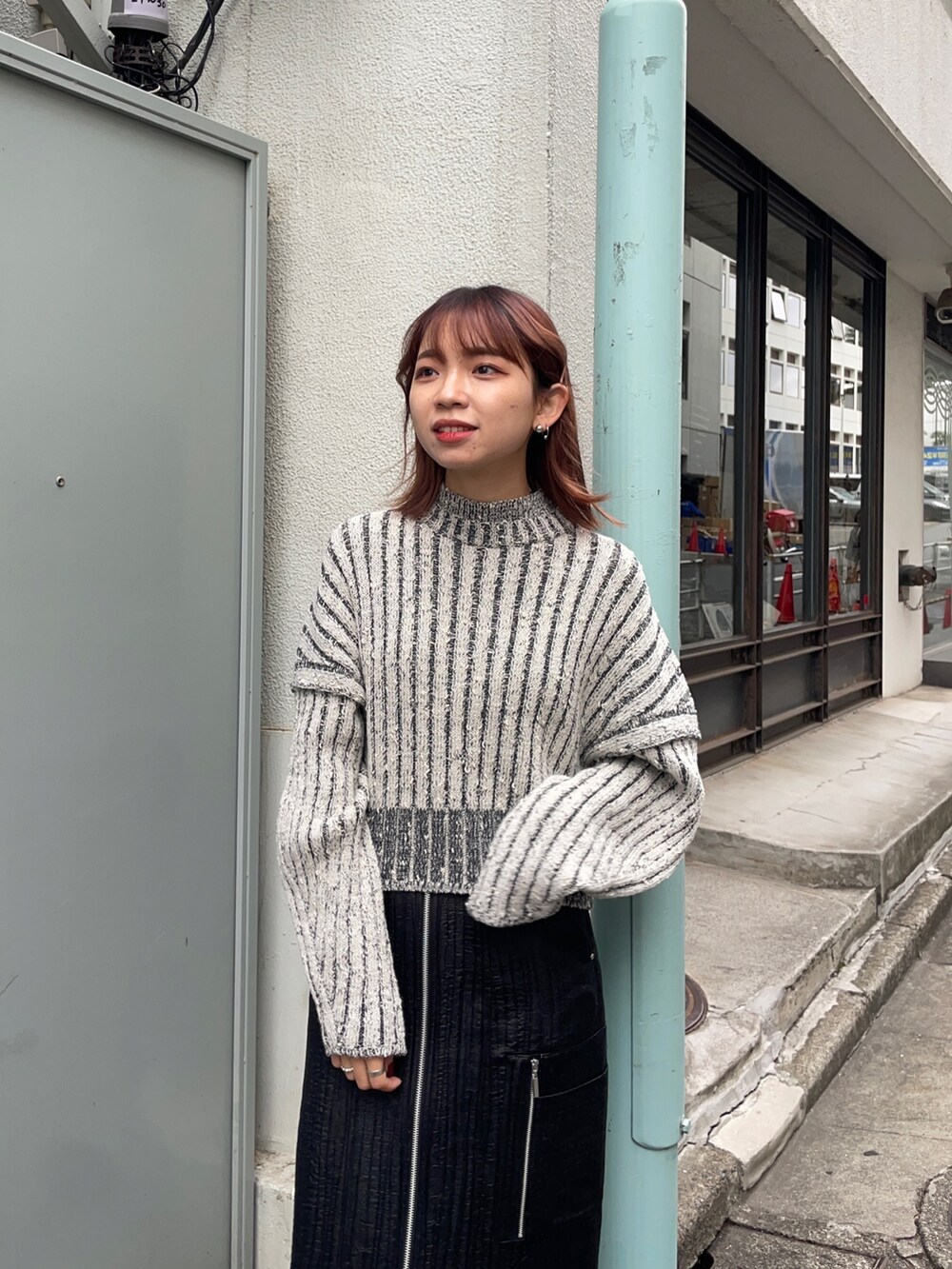 ホワイト系のニット/セーター、ブラック系のスカート、シルバー系のブーツを着用したレディースの秋コーディネートの5枚目の写真