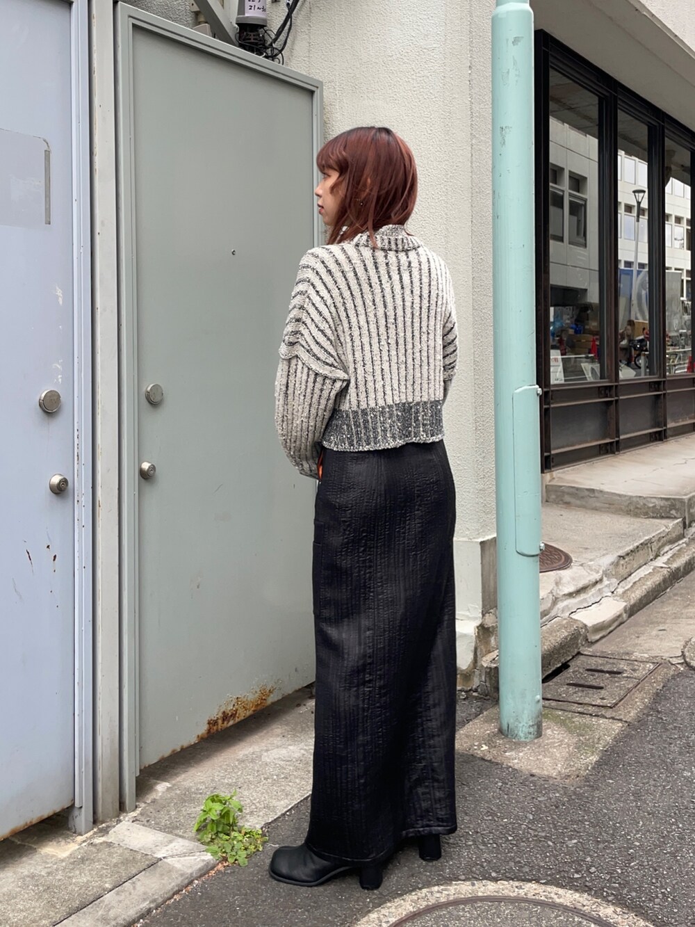 ホワイト系のニット/セーター、ブラック系のスカート、シルバー系のブーツを着用したレディースの秋コーディネートの2枚目の写真