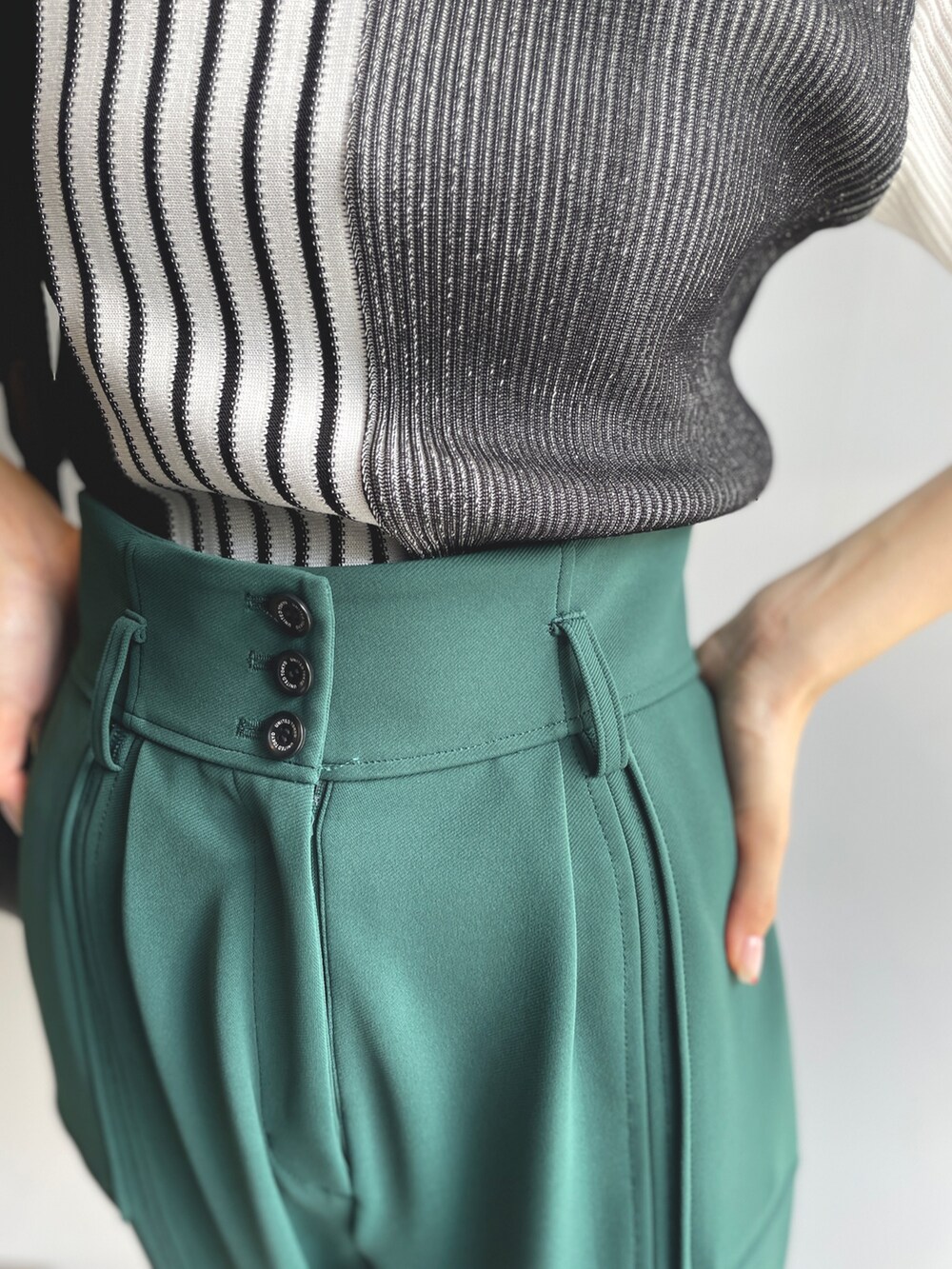 ブラック系のニット/セーター、グリーン系のその他パンツを着用したレディースの夏コーディネートの6枚目の写真