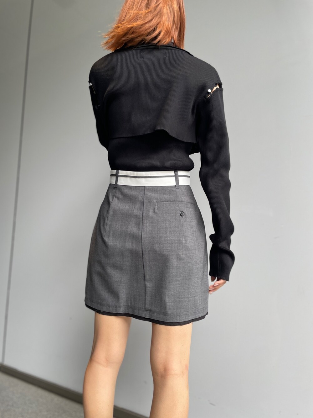 グレー系のスカート、ブラック系のニット/セーターを着用したレディースの秋コーディネートの6枚目の写真