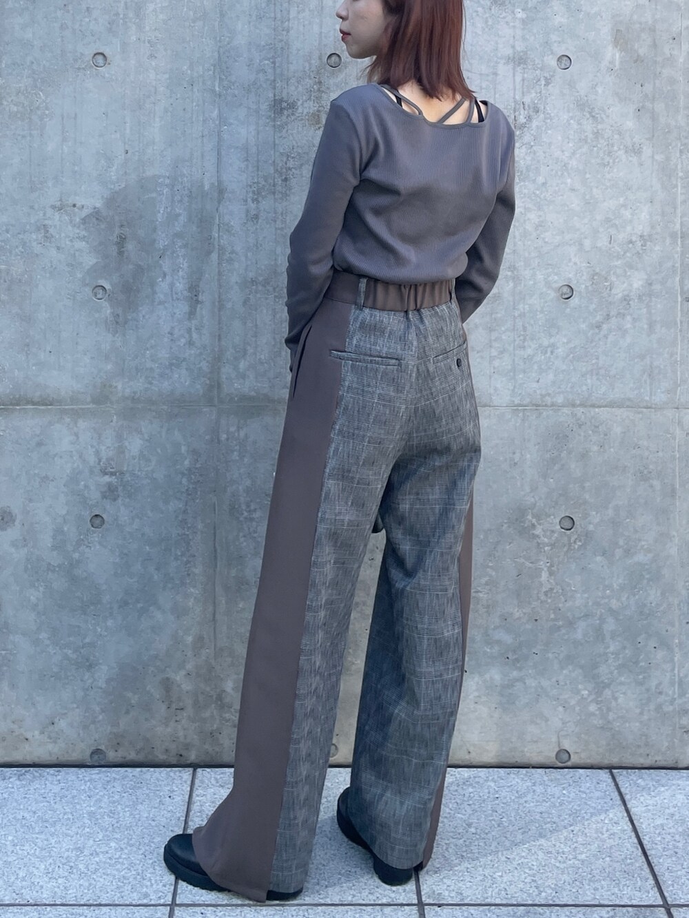 シルバー系のショルダーバッグ、グレー系のTシャツ/カットソー、ブラウン系のスラックスを着用したレディースの秋コーディネートの2枚目の写真