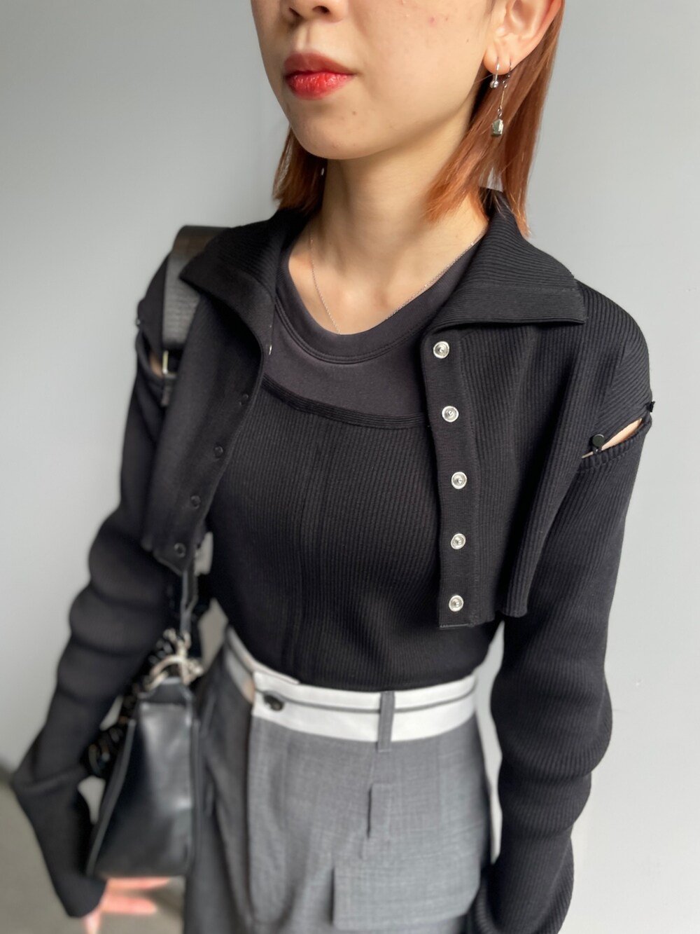 グレー系のスカート、ブラック系のニット/セーターを着用したレディースの秋コーディネートの3枚目の写真