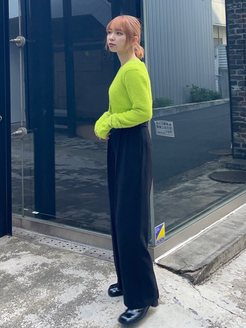 グリーン系のニット/セーターを着用したレディースの冬コーディネートの2枚目の写真