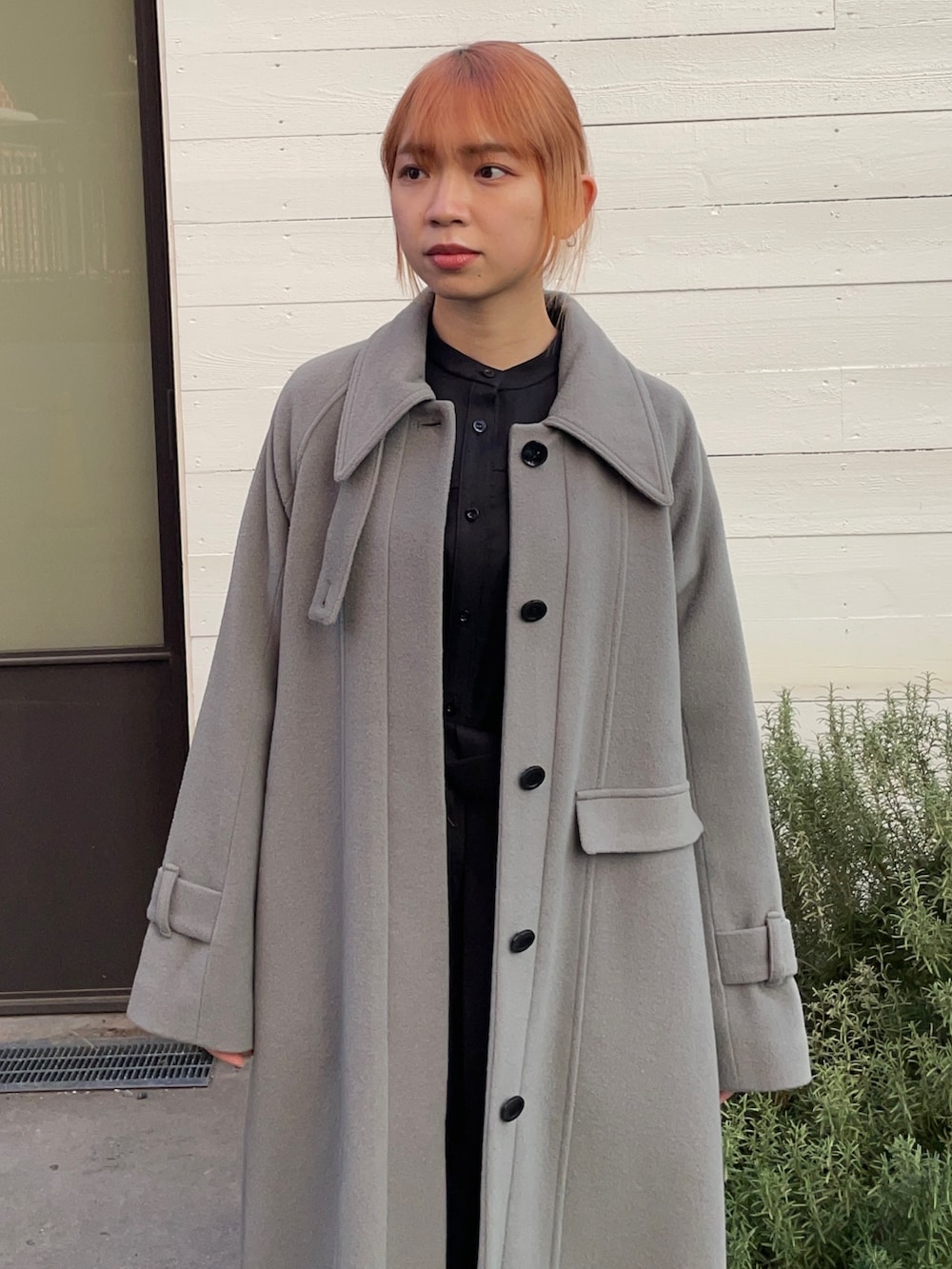 グリーン系のステンカラーコートを着用したレディースの冬コーディネートの3枚目の写真