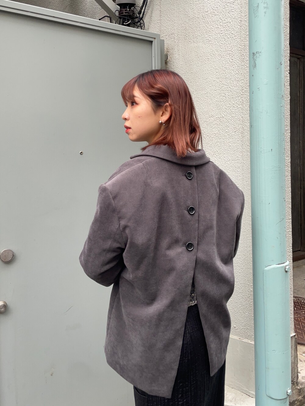 グレー系のテーラードジャケット、ホワイト系のニット/セーター、ブラック系のブーツを着用したレディースの秋コーディネートの4枚目の写真