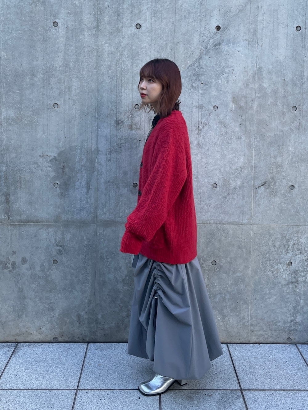 シルバー系のショルダーバッグ、グレー系のスカート、シルバー系のブーツを着用したレディースの秋コーディネートの2枚目の写真