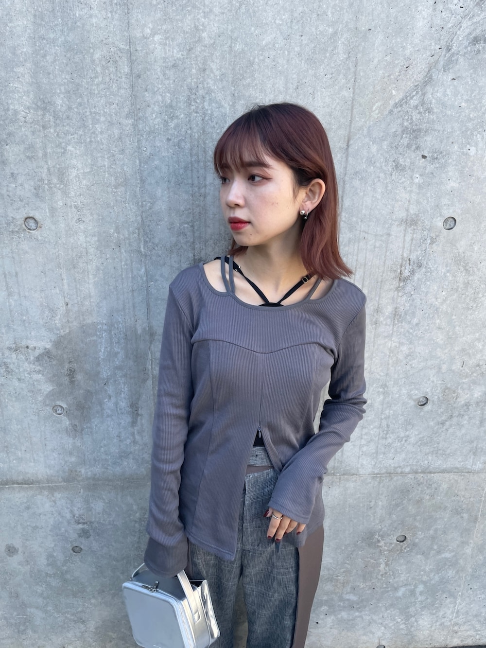 シルバー系のショルダーバッグ、グレー系のTシャツ/カットソー、ブラウン系のスラックスを着用したレディースの秋コーディネートの4枚目の写真