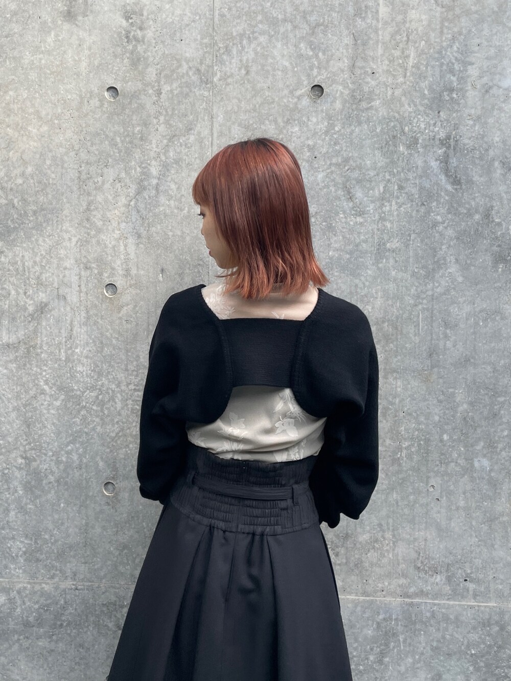 ブラック系のスカート、ブラック系のカーディガン/ボレロ、ベージュ系のTシャツ/カットソーを着用したレディースの秋コーディネートの4枚目の写真