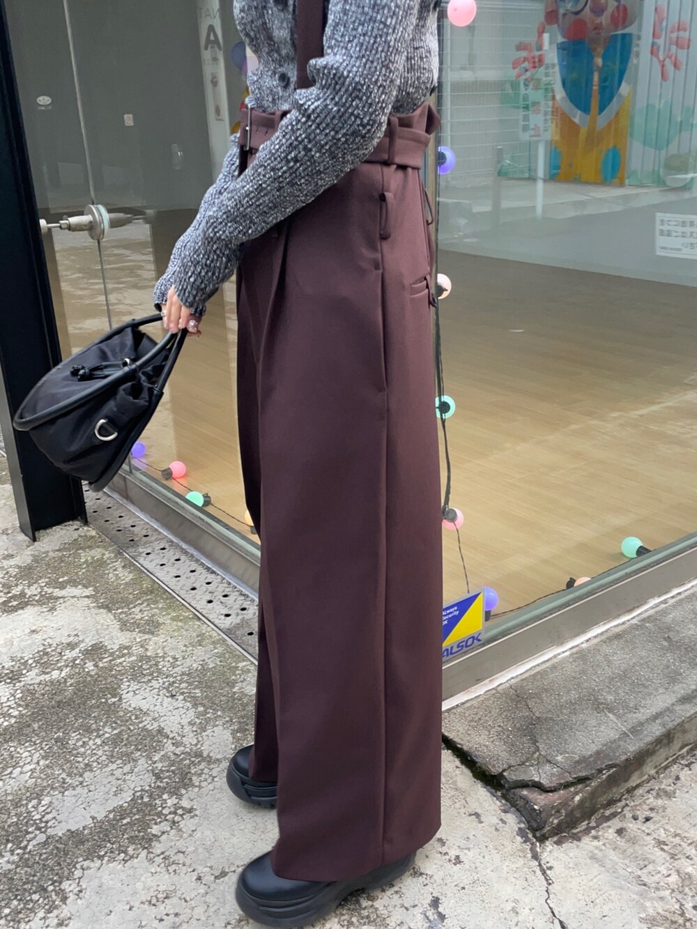 ブラック系のニット/セーター、ブラック系のショルダーバッグを着用したレディースの冬コーディネートの6枚目の写真