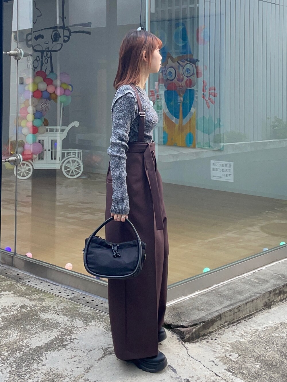 ブラック系のニット/セーター、ブラック系のショルダーバッグを着用したレディースの冬コーディネートの3枚目の写真