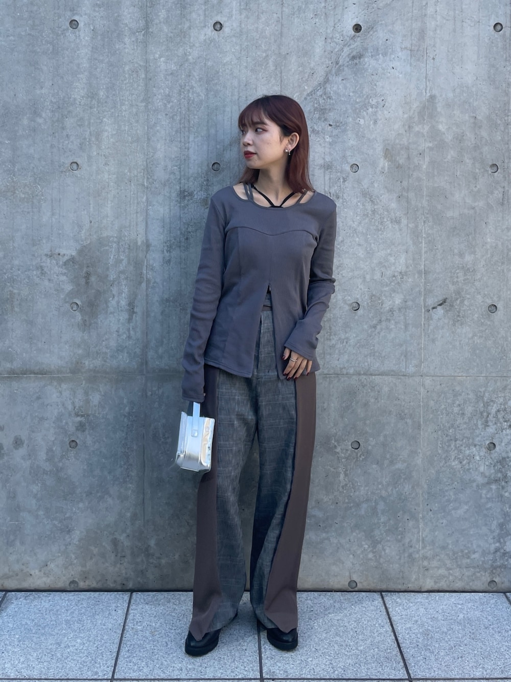 シルバー系のショルダーバッグ、グレー系のTシャツ/カットソー、ブラウン系のスラックスを着用したレディースの秋コーディネートの3枚目の写真