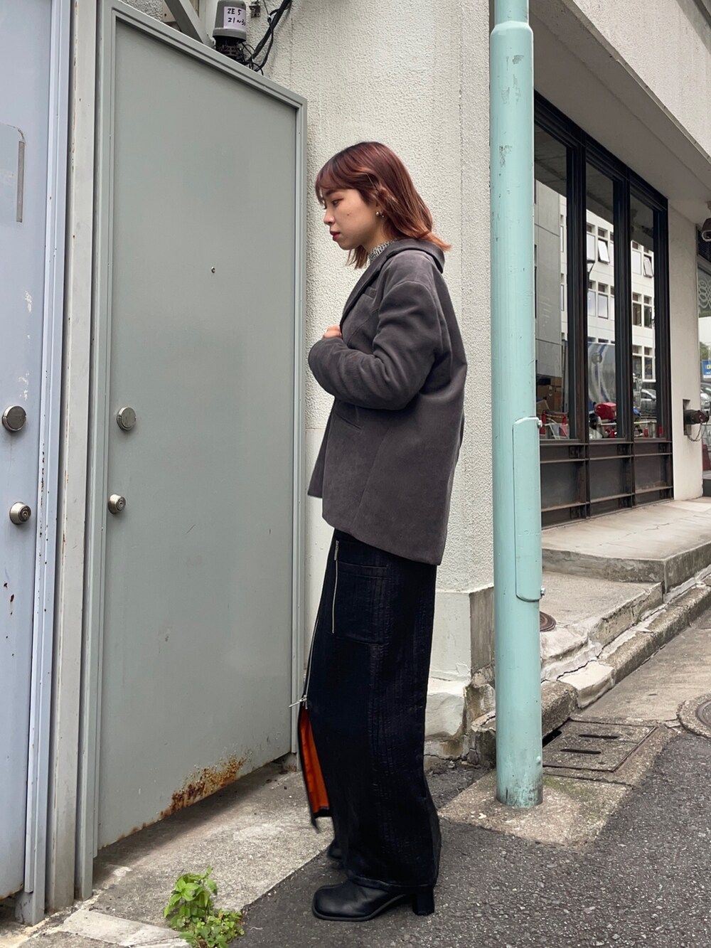 グレー系のテーラードジャケット、ホワイト系のニット/セーター、ブラック系のブーツを着用したレディースの秋コーディネートの2枚目の写真