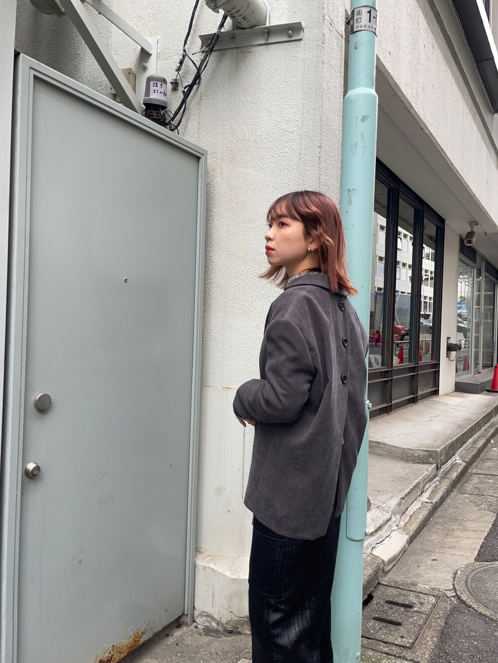 グレー系のテーラードジャケット、ホワイト系のニット/セーター、ブラック系のブーツを着用したレディースの秋コーディネートの3枚目の写真