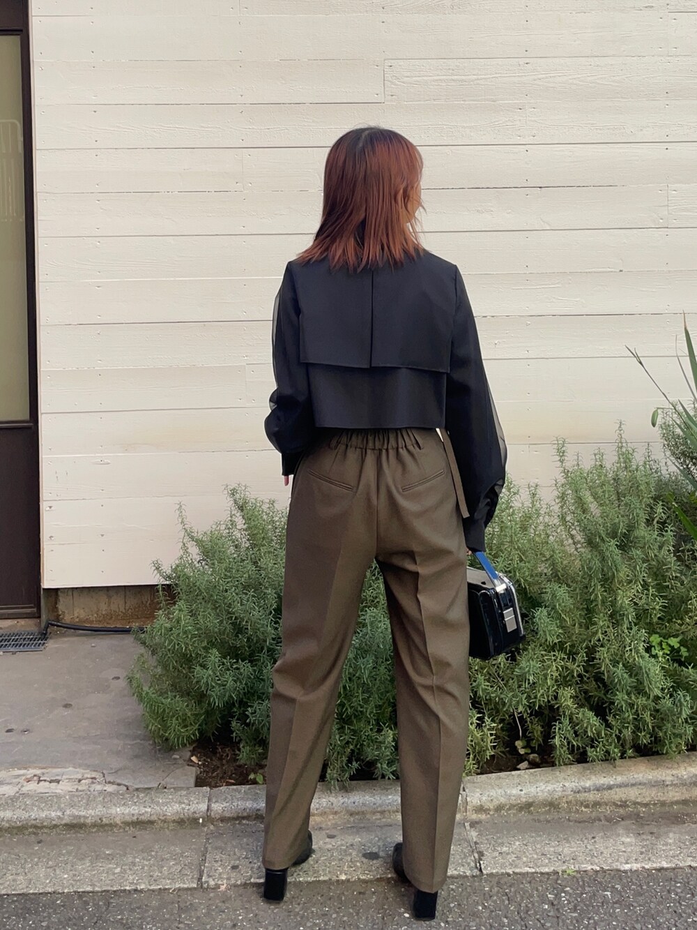 ブラック系のショルダーバッグ、ブラウン系のその他パンツ、ブラック系のシャツ/ブラウスを着用したレディースの秋コーディネートの2枚目の写真