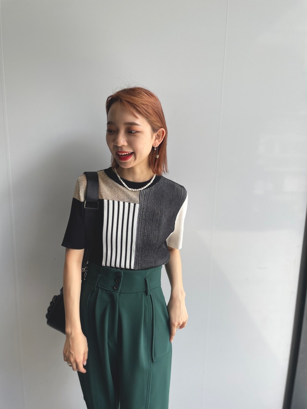 ブラック系のニット/セーター、グリーン系のその他パンツを着用したレディースの夏コーディネートの4枚目の写真