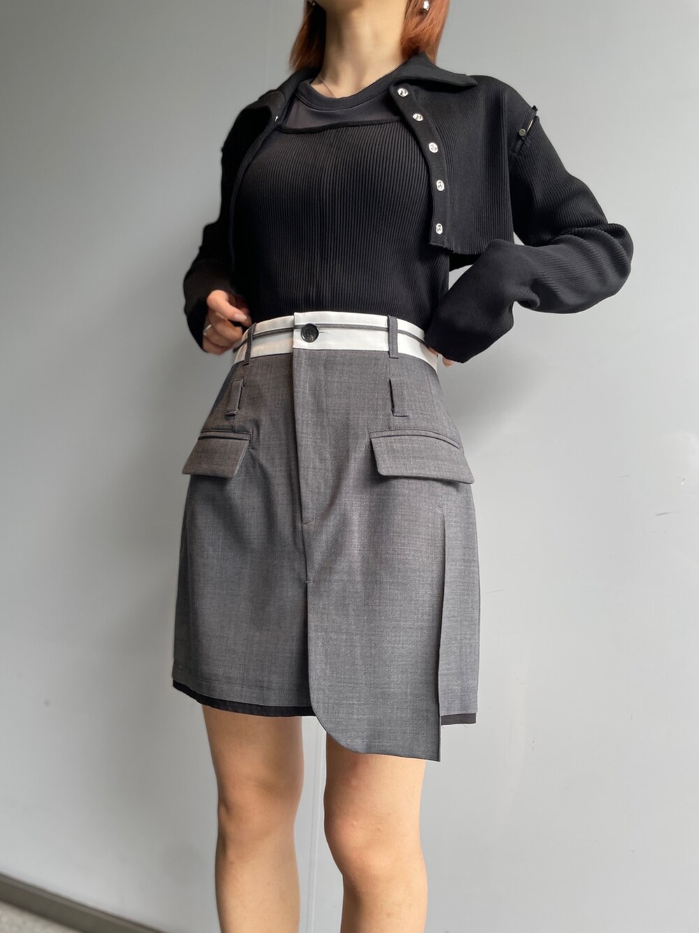 グレー系のスカート、ブラック系のニット/セーターを着用したレディースの秋コーディネートの5枚目の写真