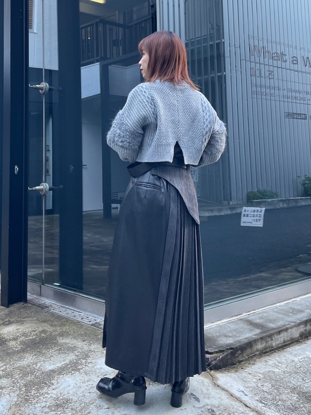 グレー系のニット/セーター、ブラック系のスカートを着用したレディースの冬コーディネートの2枚目の写真