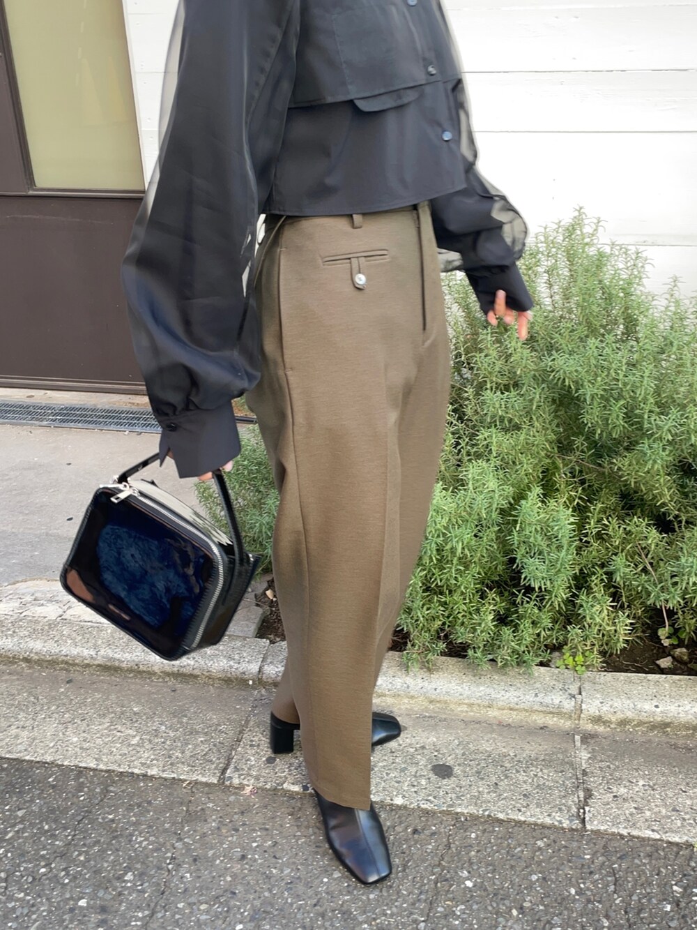 ブラック系のショルダーバッグ、ブラウン系のその他パンツ、ブラック系のシャツ/ブラウスを着用したレディースの秋コーディネートの4枚目の写真