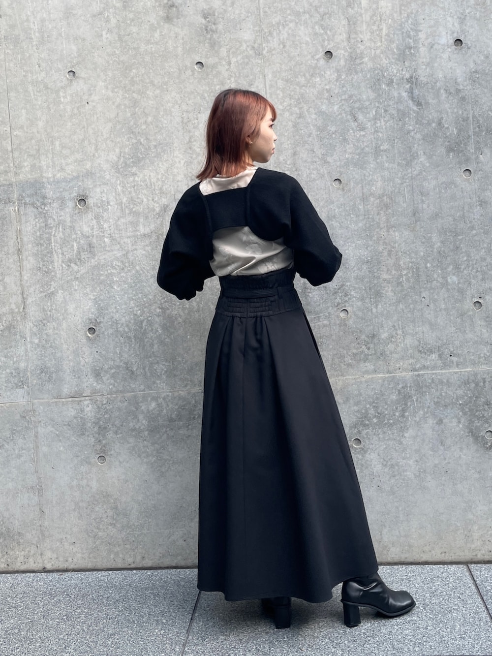 ブラック系のスカート、ブラック系のカーディガン/ボレロ、ベージュ系のTシャツ/カットソーを着用したレディースの秋コーディネートの2枚目の写真