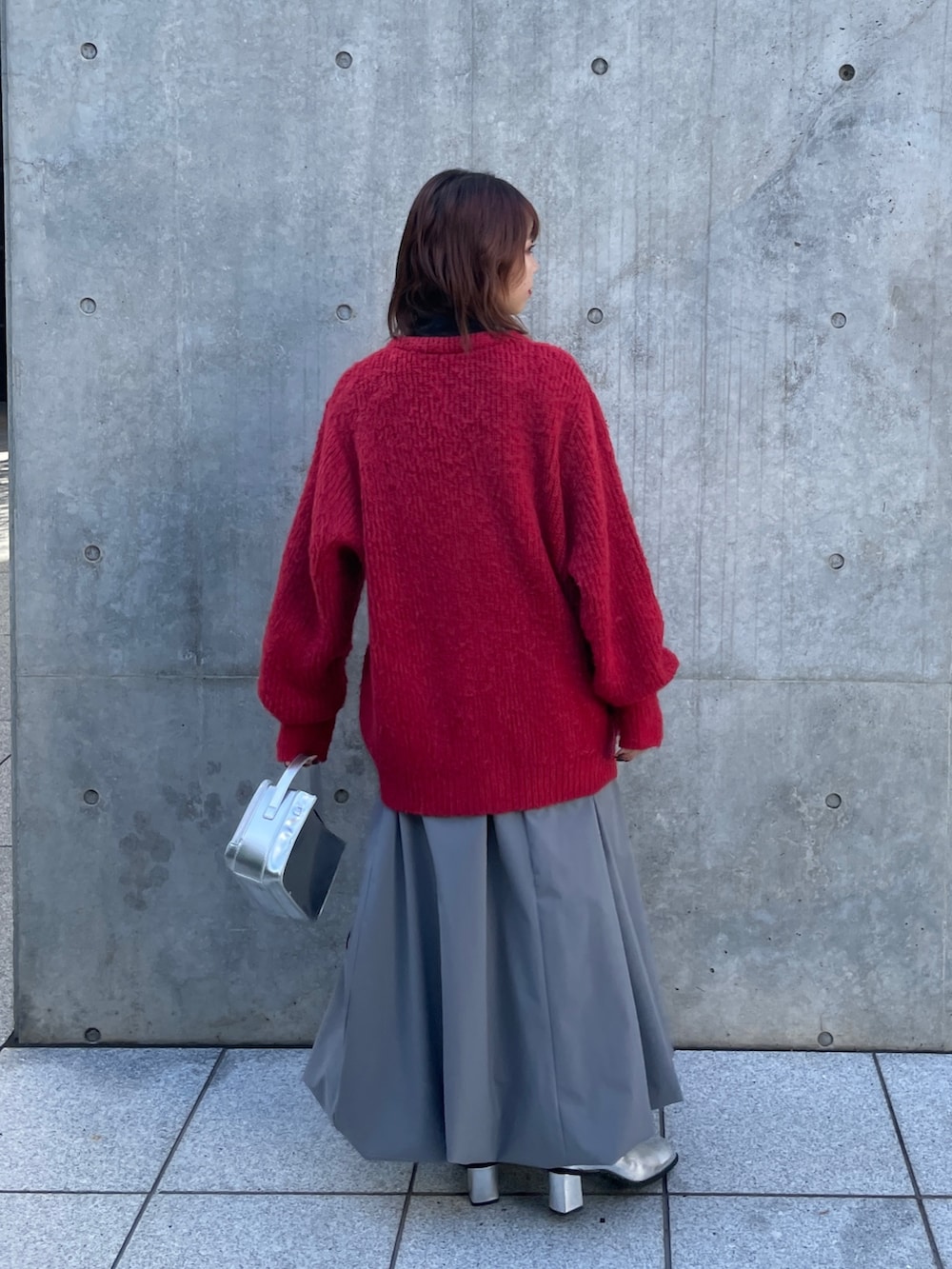 シルバー系のショルダーバッグ、グレー系のスカート、シルバー系のブーツを着用したレディースの秋コーディネートの3枚目の写真