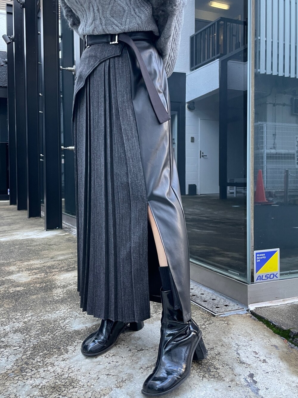 グレー系のニット/セーター、ブラック系のスカートを着用したレディースの冬コーディネートの6枚目の写真