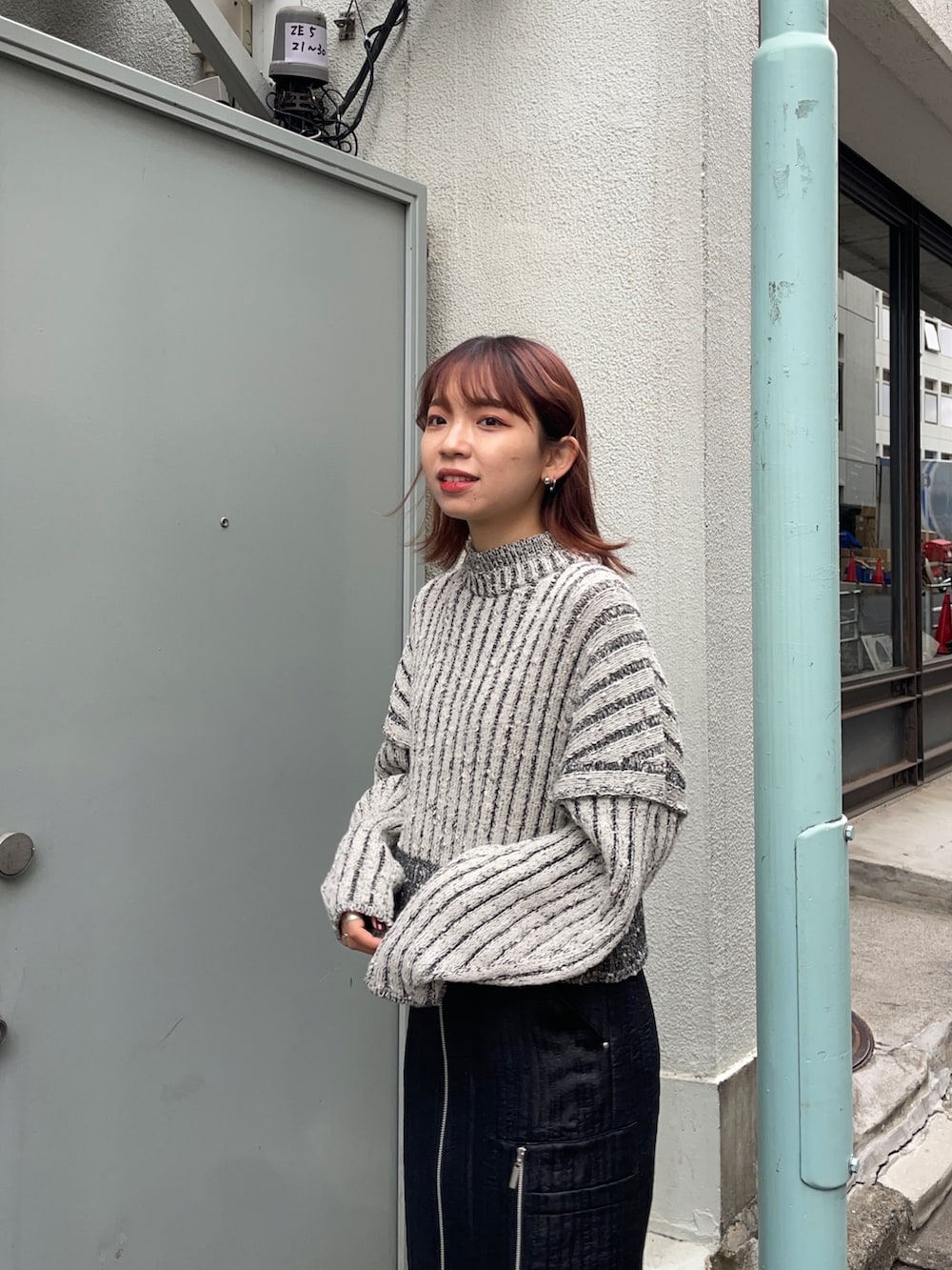 ホワイト系のニット/セーター、ブラック系のスカート、シルバー系のブーツを着用したレディースの秋コーディネートの4枚目の写真