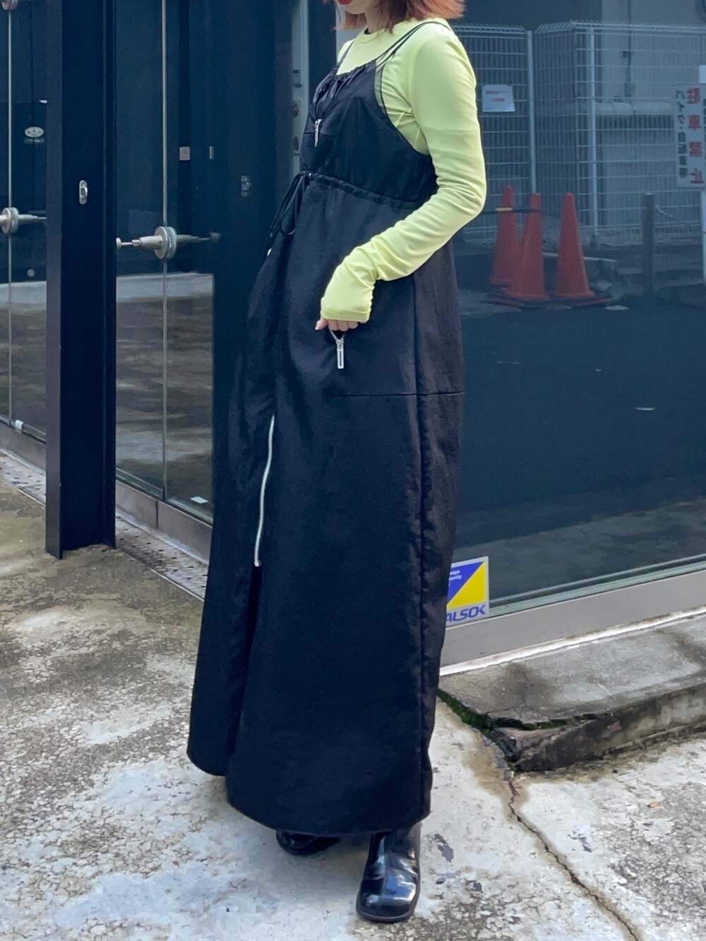 ブラック系のジャンパースカート、グリーン系のTシャツ/カットソーを着用したレディースの冬コーディネートの3枚目の写真