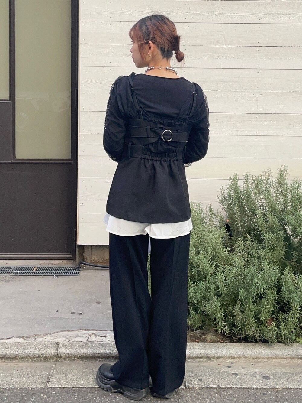 ブラック系のベスト、ブラック系のTシャツ/カットソー、ブラック系のスラックスを着用したレディースの冬コーディネートの2枚目の写真