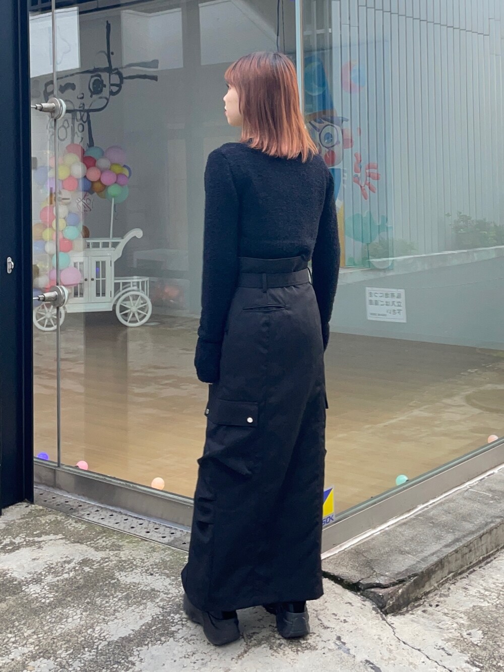 ブラック系のニット/セーター、ブラック系のスカートを着用したレディースの冬コーディネートの2枚目の写真