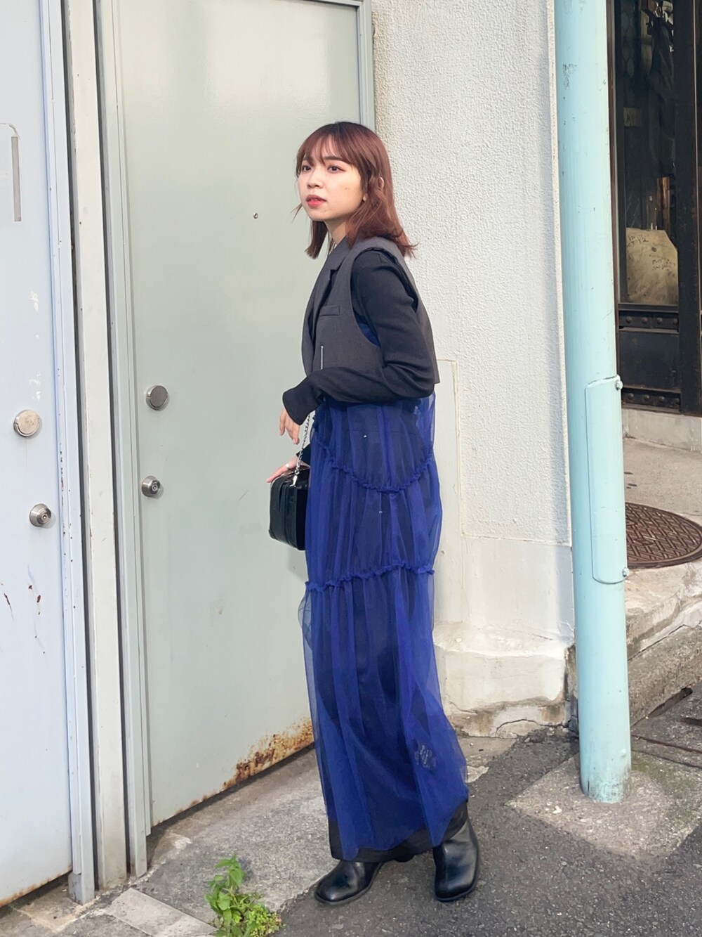 ブラック系のブーツ、グレー系のワンピース、ブラック系のTシャツ/カットソーを着用したレディースの秋コーディネートの2枚目の写真