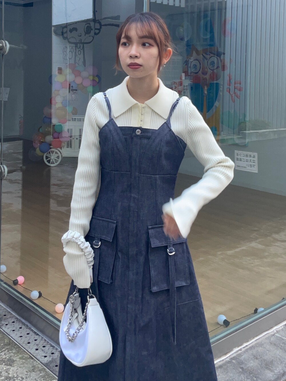 ブルー系のジャンパースカート、ホワイト系のニット/セーターを着用したレディースの冬コーディネートの3枚目の写真