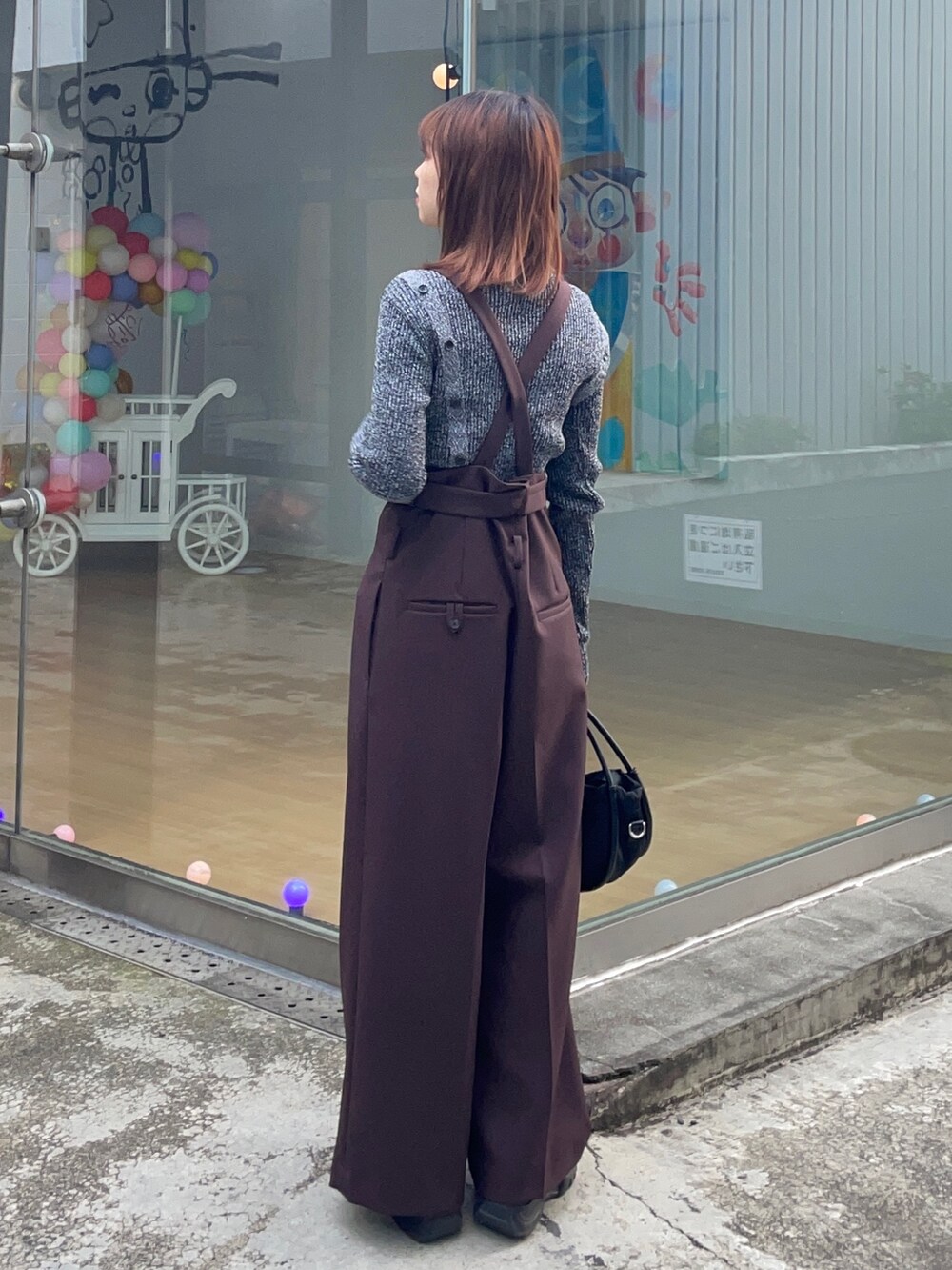 ブラック系のニット/セーター、ブラック系のショルダーバッグを着用したレディースの冬コーディネートの2枚目の写真