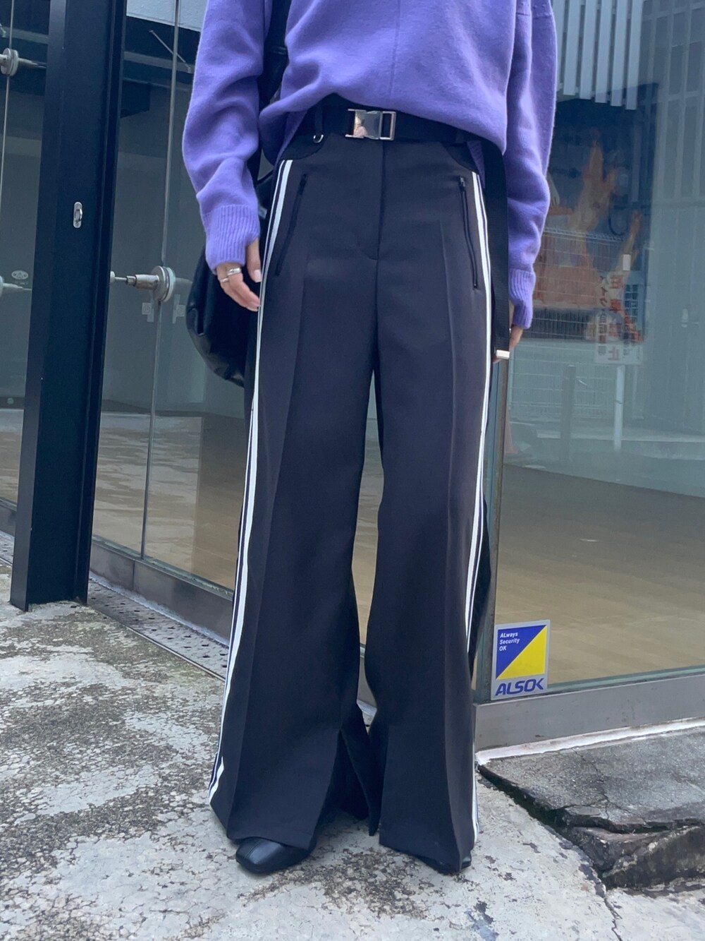 グレー系のその他パンツ、パープル系のニット/セーター、ブラック系のブーツを着用したレディースの秋コーディネートの5枚目の写真