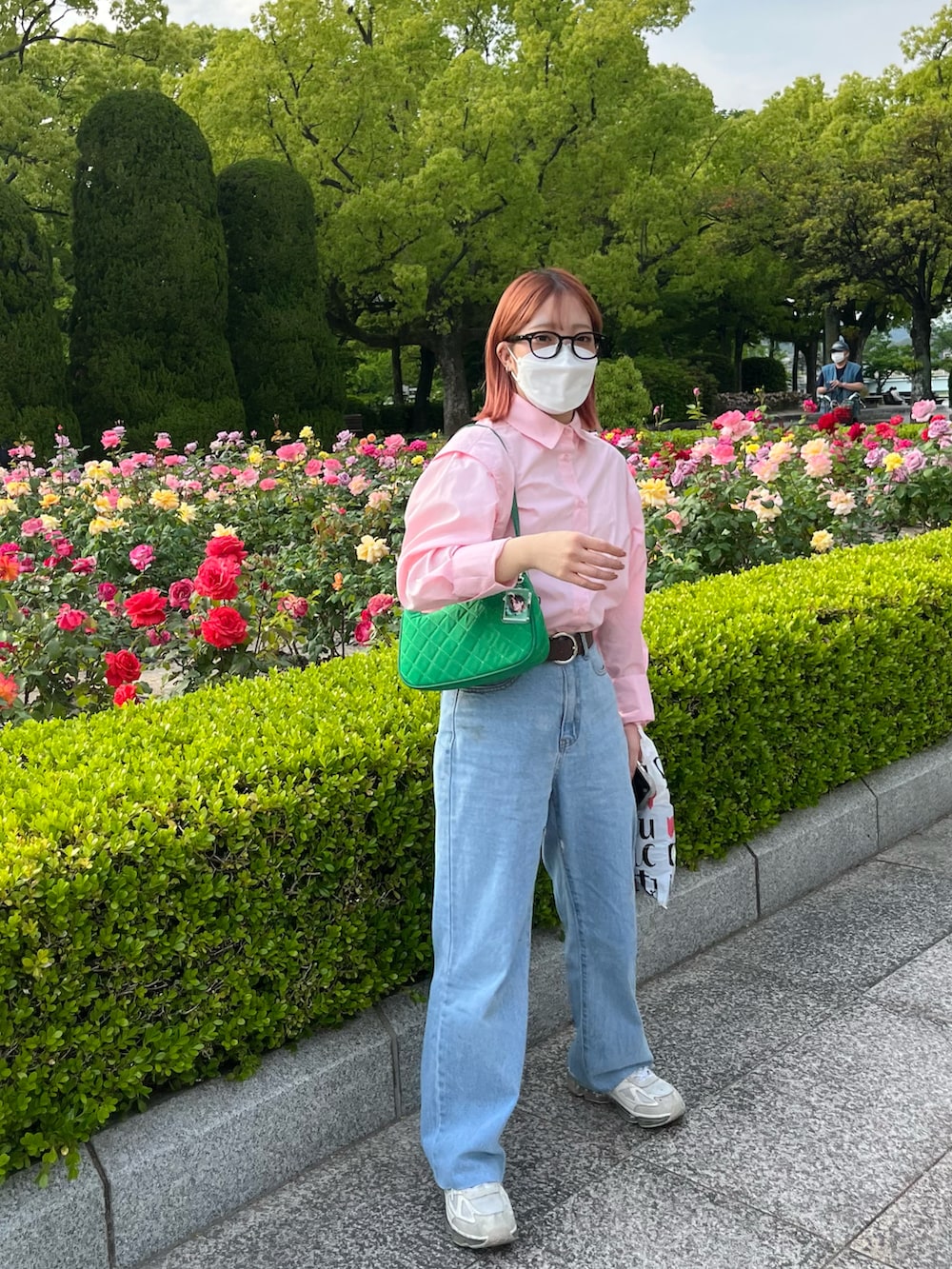 ピンク系のシャツ/ブラウス、ブルー系のデニムパンツ、ホワイト系のスニーカーを着用したレディースの春コーディネートの2枚目の写真