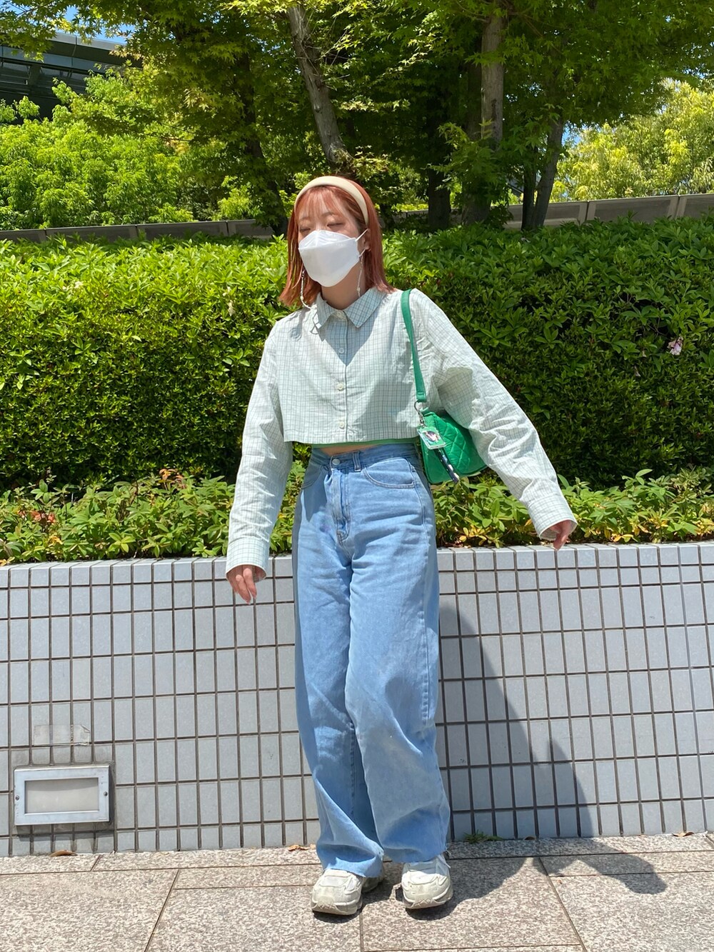 ブルー系のデニムパンツ、グリーン系のシャツ/ブラウス、ホワイト系のスニーカーを着用したレディースの春コーディネートの2枚目の写真