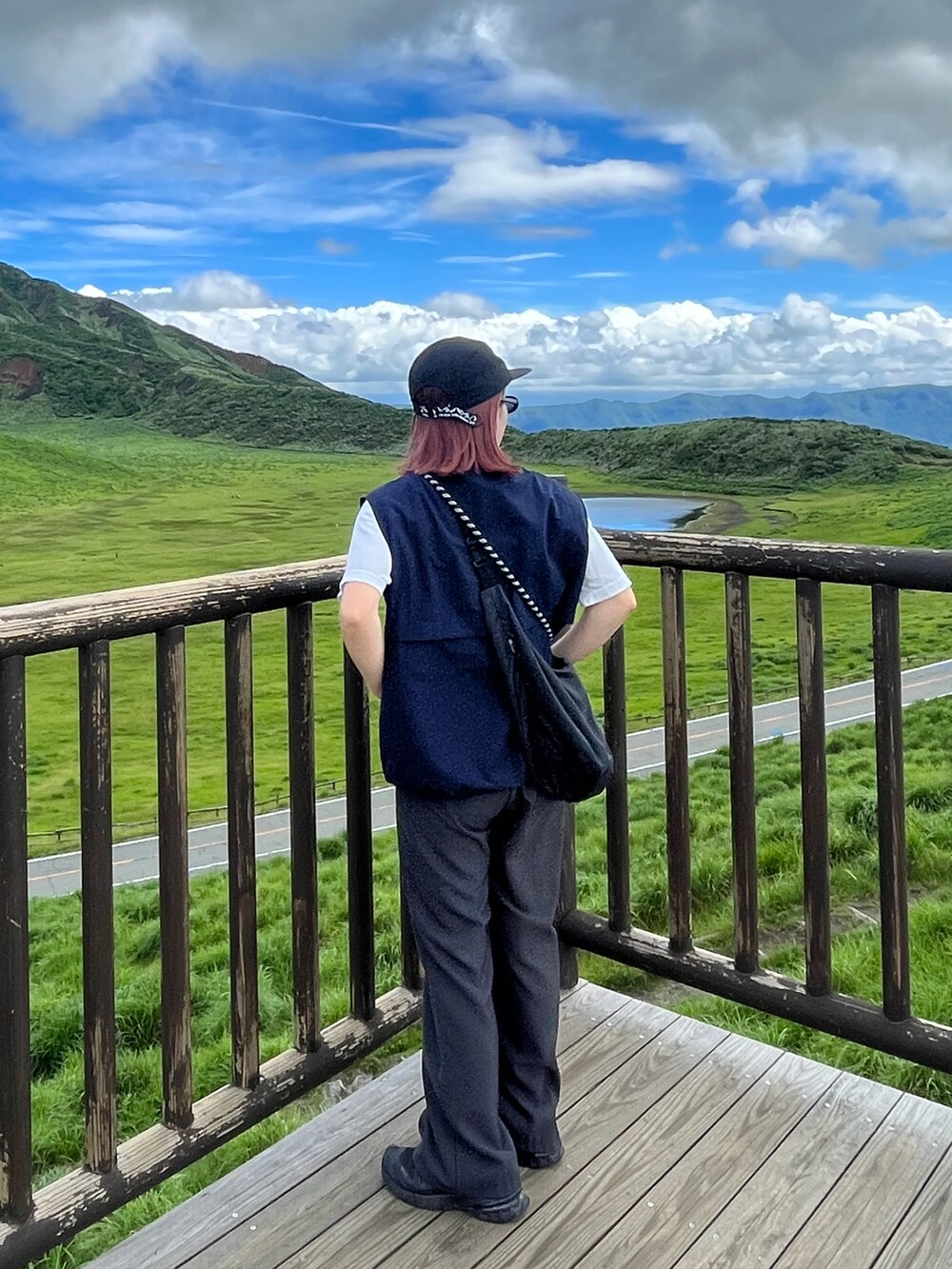 ブルー系のベスト、ブラック系のスニーカー、ブラック系のキャップを着用したレディースの夏コーディネートの2枚目の写真